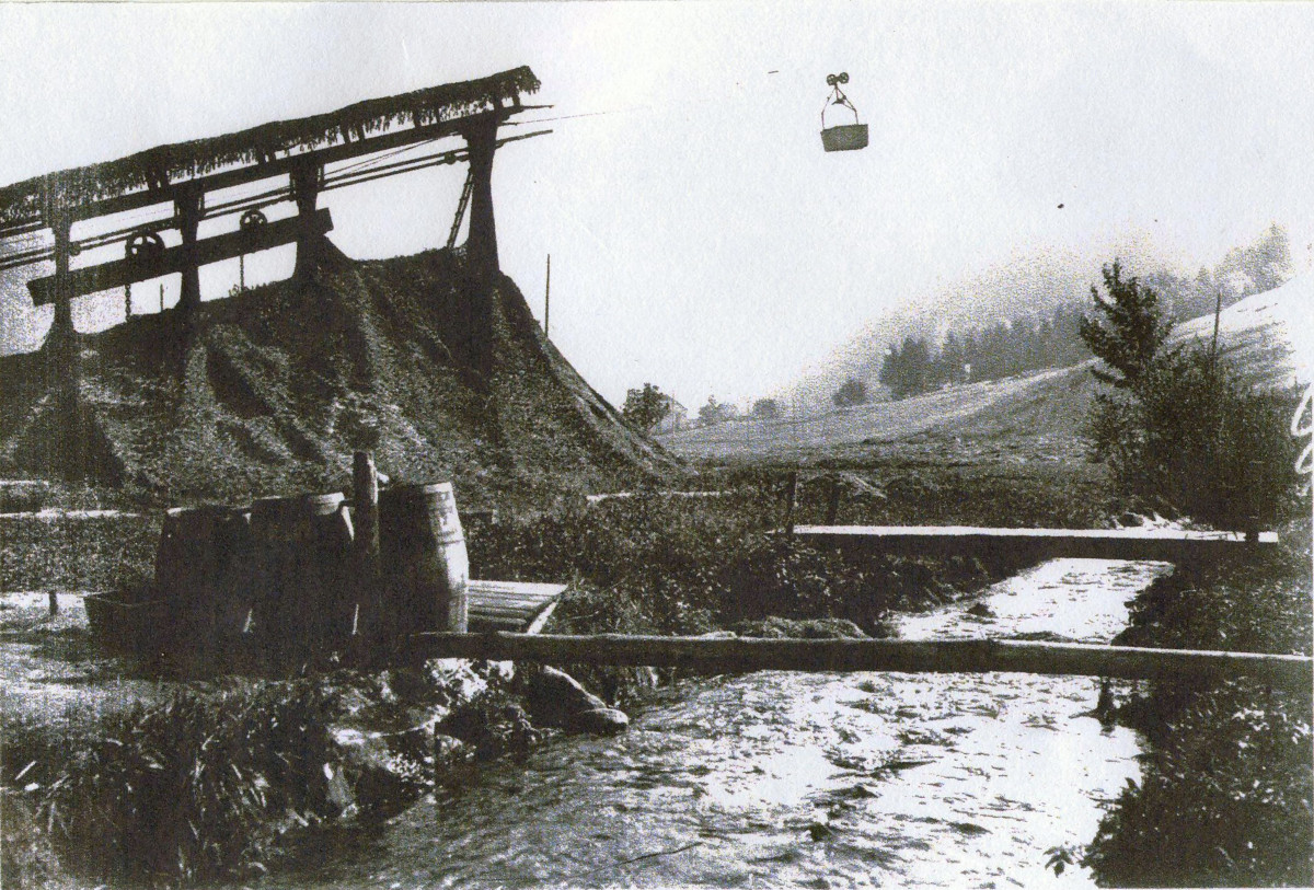 Gare du Valtin, départ d'une nacelle du téléphérique vers Gazon Martin <small>(alt. 1185 m)</small>,<br>câble porteur de 2560 m soutenu par 29 pylônes de bois ou métal, dénivelé 450 m.<br>Débit moyen en 1916 : 36 tonnes par jour. Au premier plan, la Meurthe. (JB).