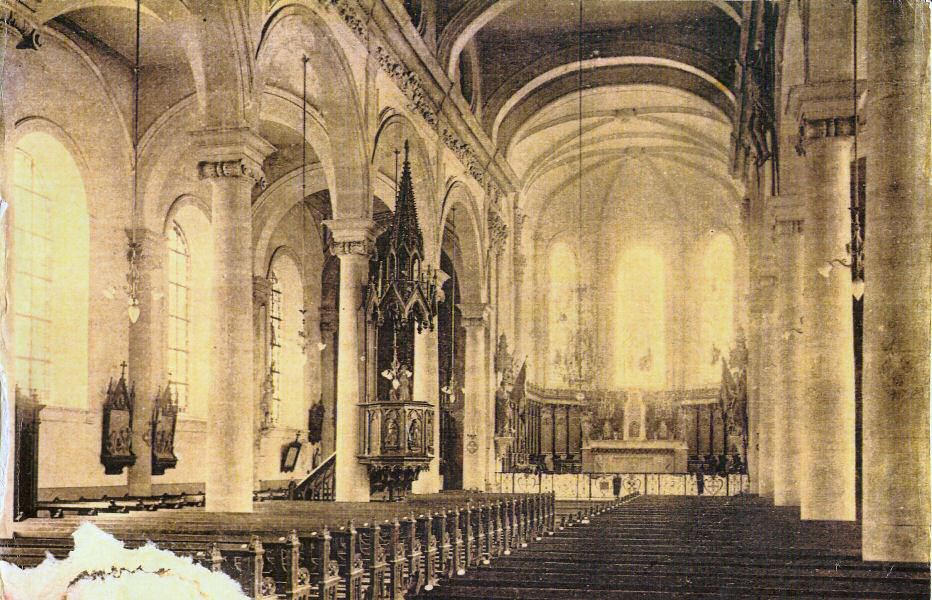 Vue des vitraux��: Extrait d'une carte postale d'entre 1929 et 1944. L'��clairage ��l��ctrique a ��t�� install��. On distingue une partie de silhouette sur le vitrail qui est au coin de l'autel de Notre-Dame, alors que les autres semblent vides.